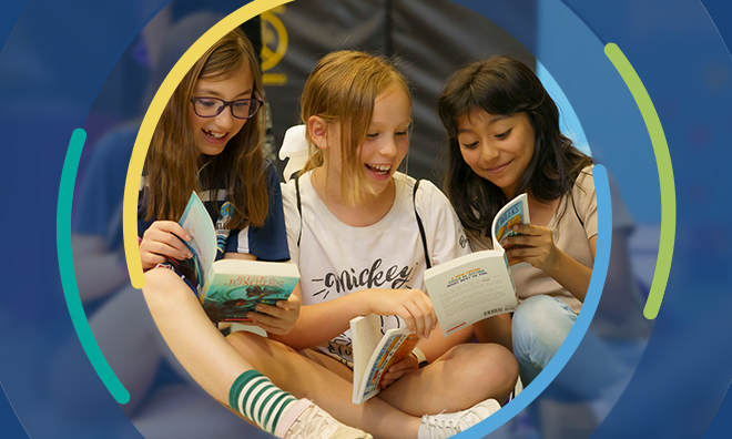 3 girls reading and laughing together