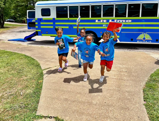 Kids running with books from the Lit Limo Bus
