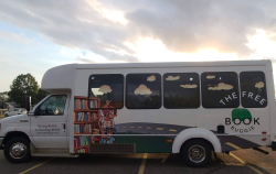 The Free Book Buggie, a bus with a design of a bookshelf along a road