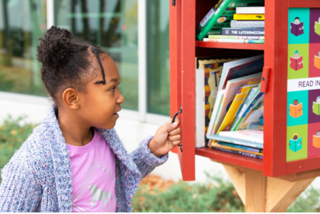Girl looking at a Little Free Library